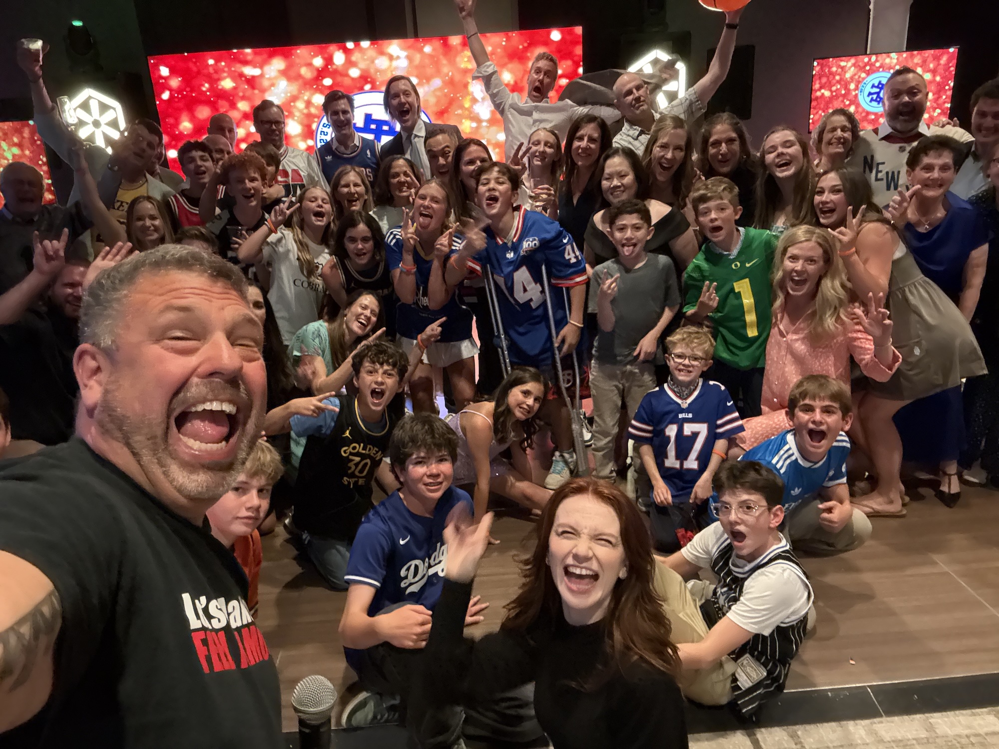 Basketball Themed Bar Mitzvah Celebration Group of people celebrating at a basketball themed bar mitzvah with a vibrant background.