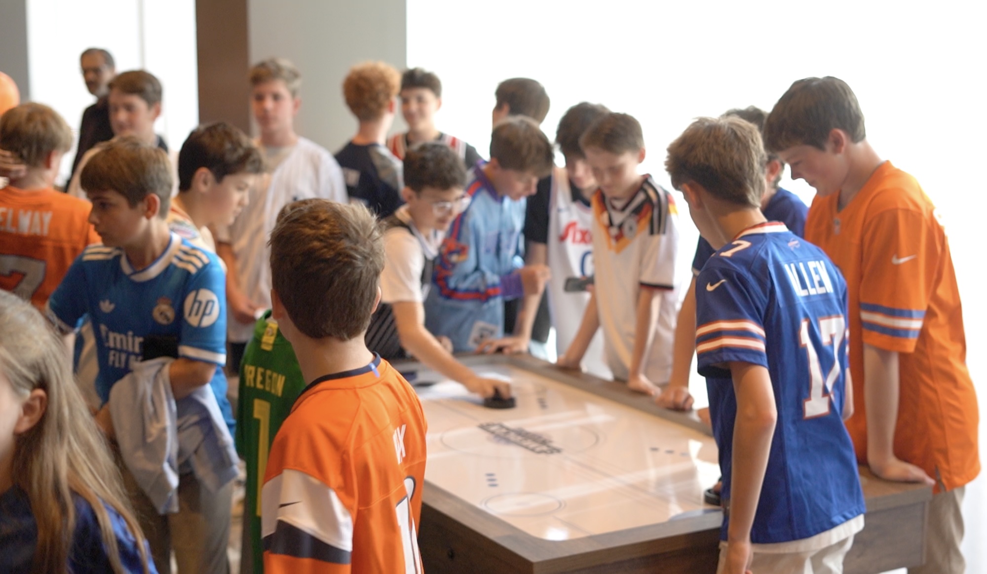 Basketball Themed Bar Mitzvah Celebration Group of boys playing air hockey at a themed event.